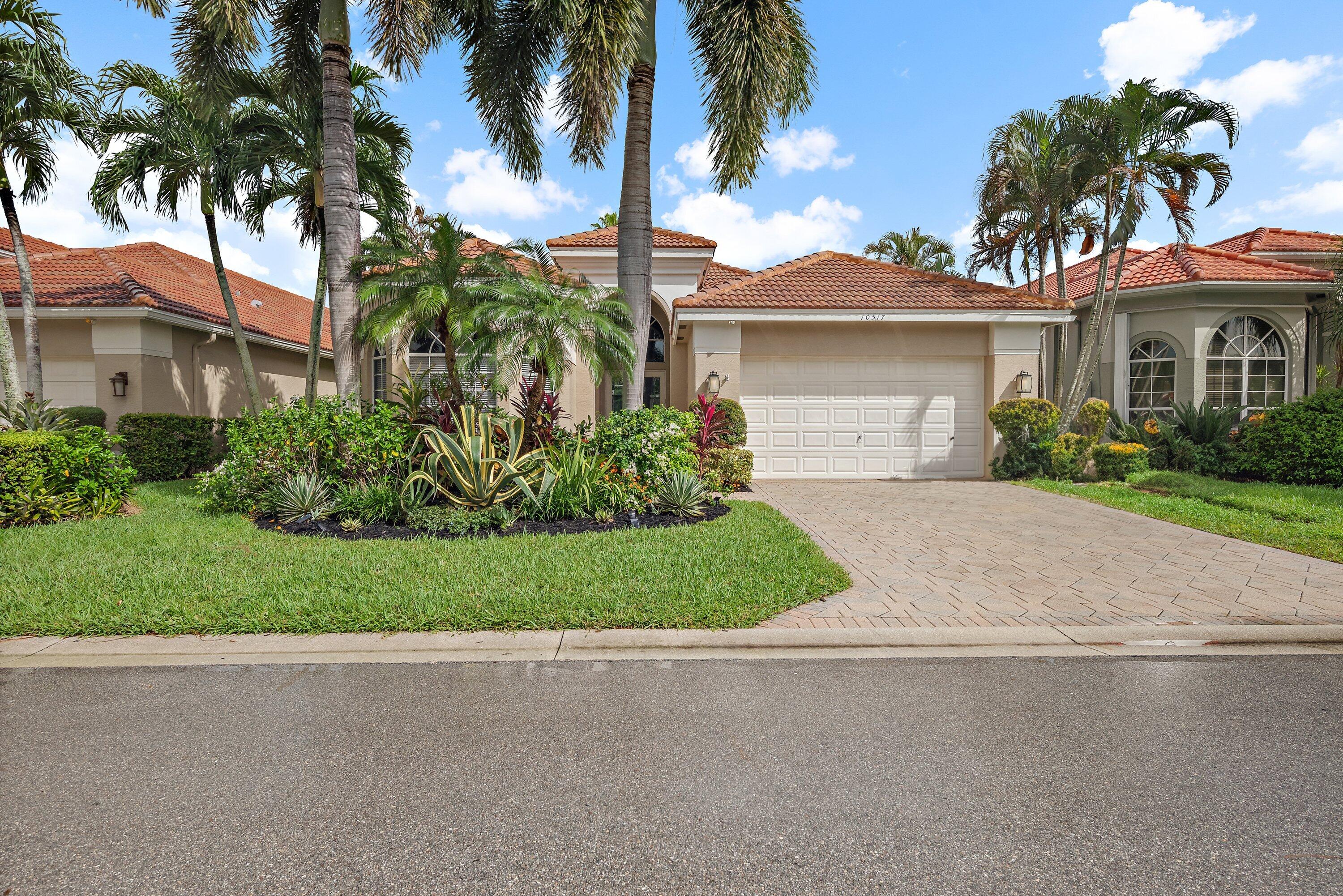 a front view of a house with a garden and a yard