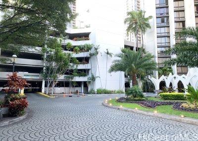 a view of a building with potted plants and palm trees