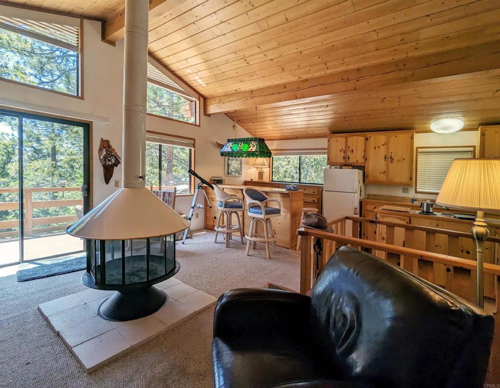 a living room with furniture a flat screen tv and floor to ceiling window