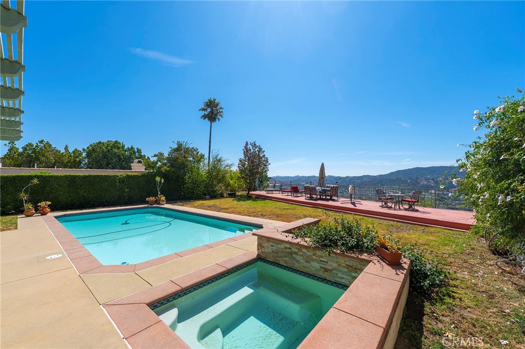 a view of a swimming pool with a yard and sitting area