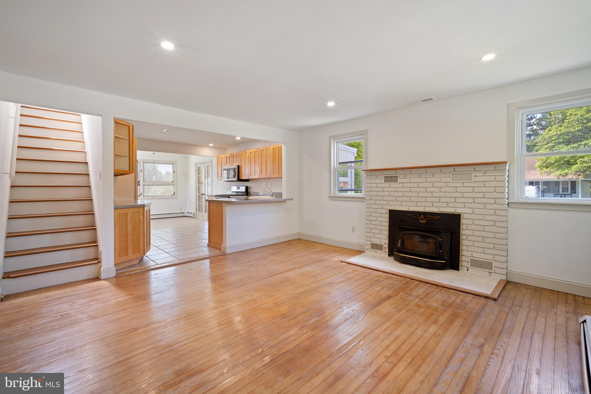 a view of a livingroom with wooden floor and a kitchen