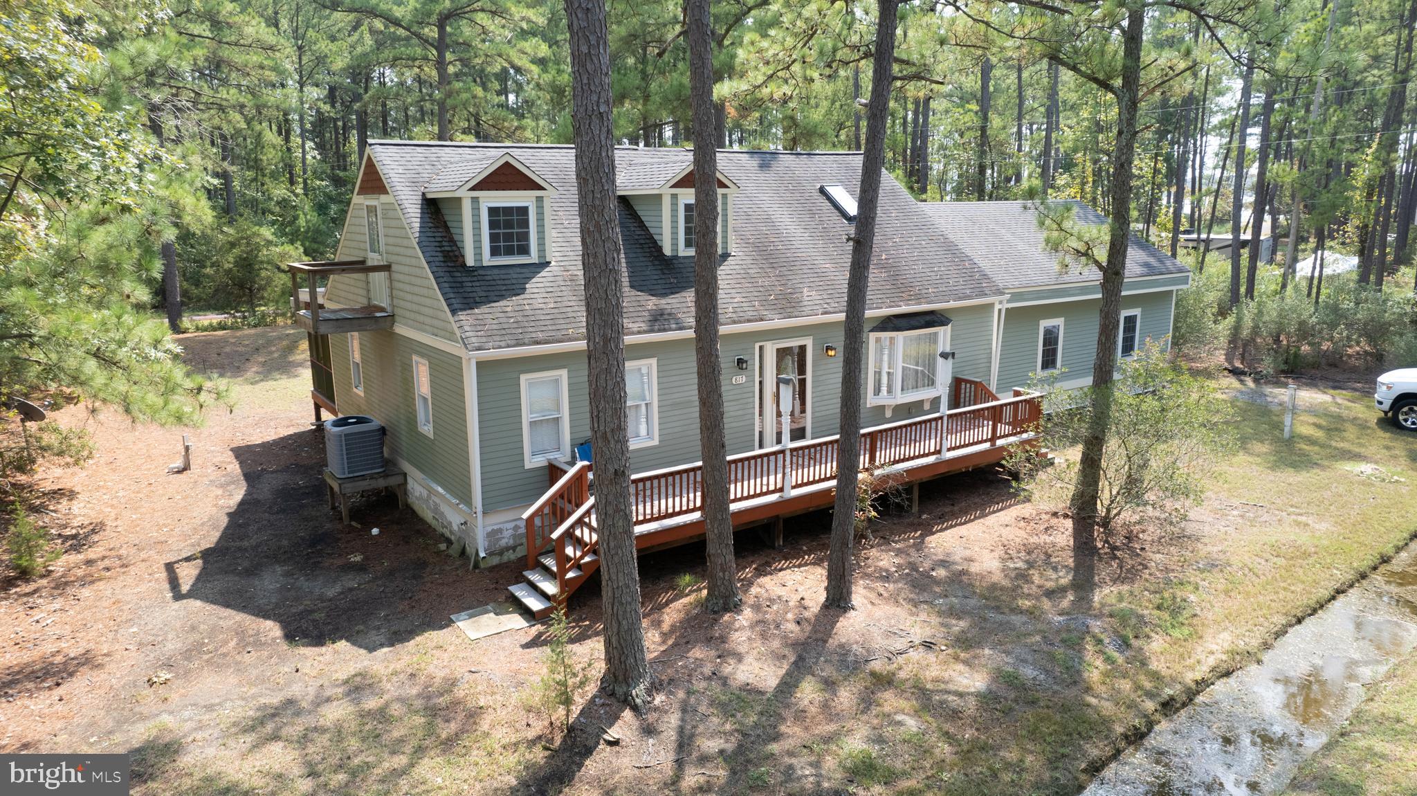 a view of a house with a wooden deck and a backyard