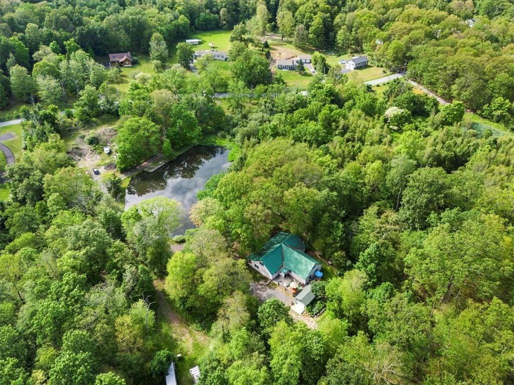 an aerial view of residential house with outdoor space and trees all around