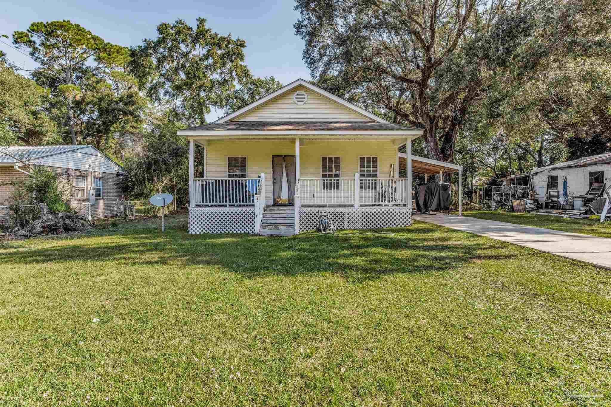 a front view of a house with swimming pool and porch with furniture