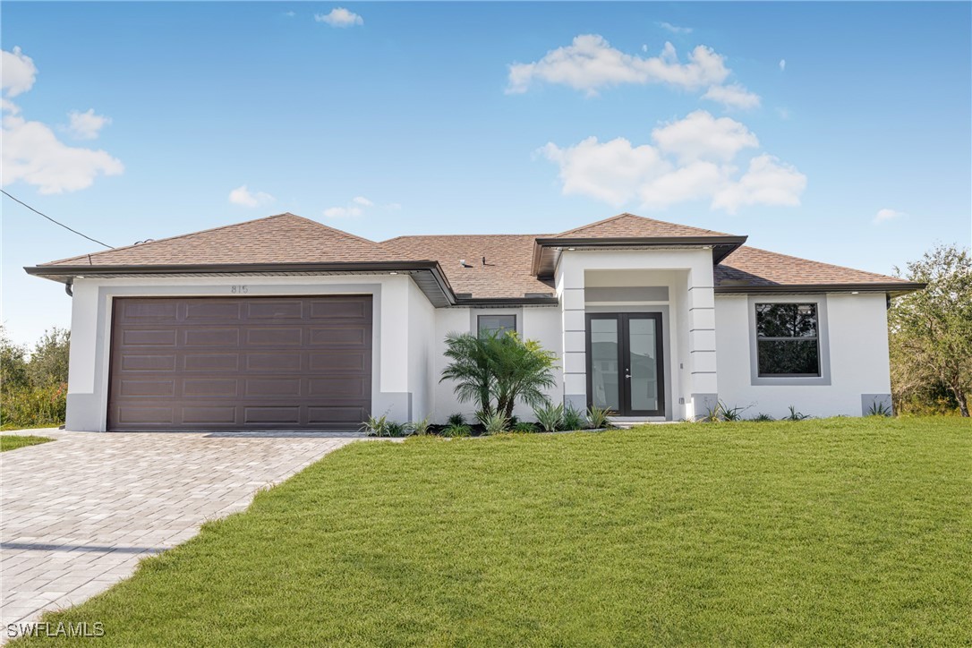 a front view of a house with a yard and garage