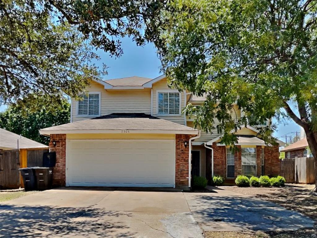 a front view of a house with a tree