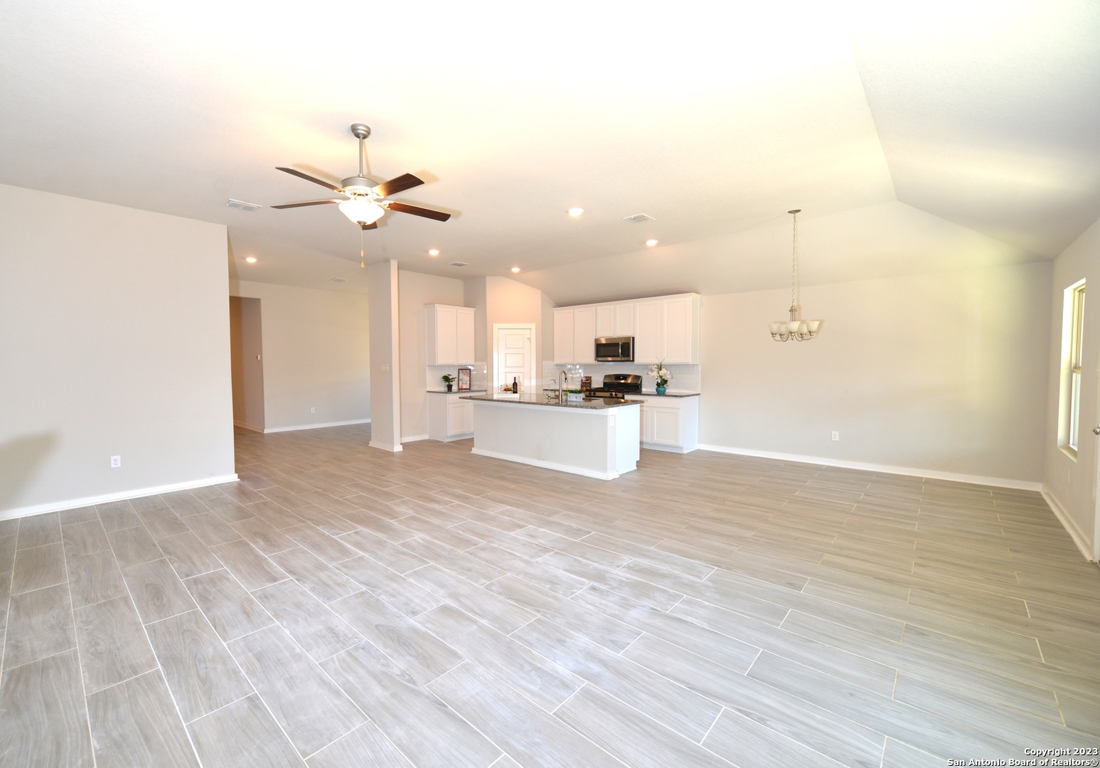 a view of kitchen with granite countertop cabinets and refrigerator