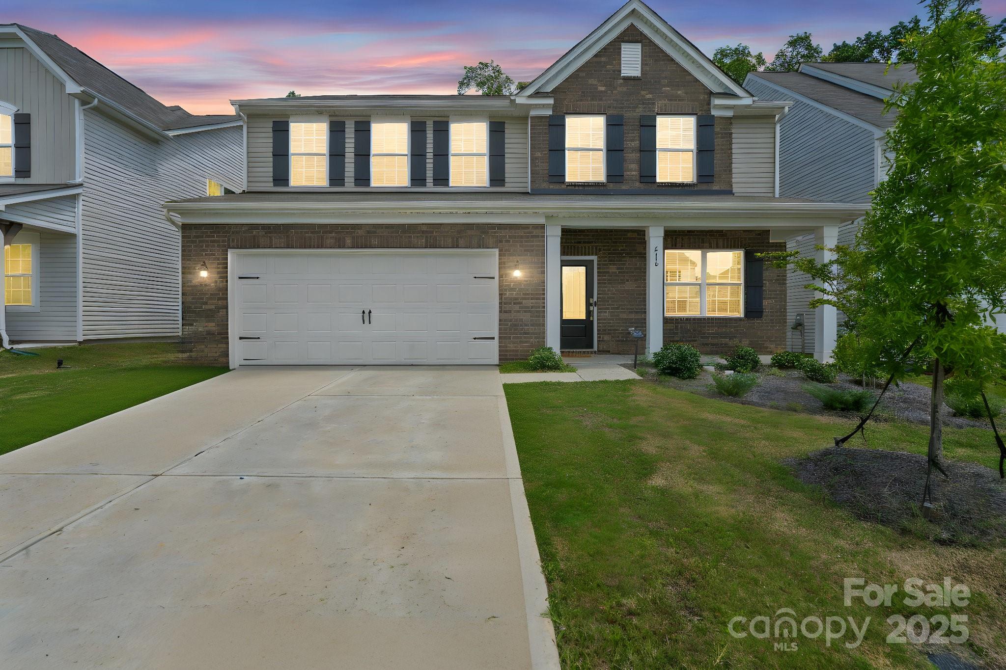 a front view of a house with a yard and garage