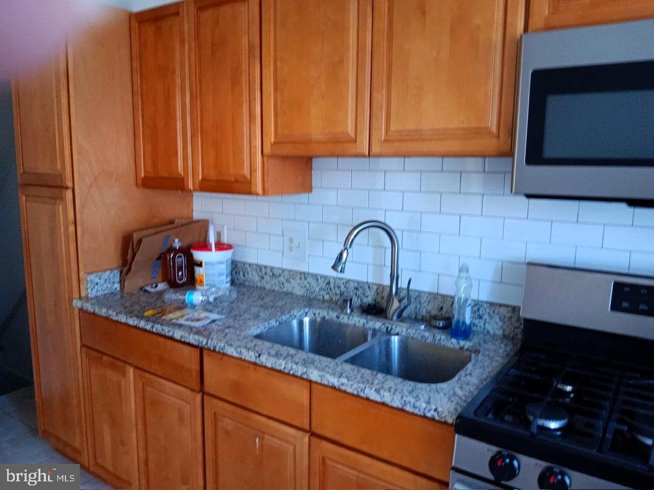 a kitchen with sink a microwave and cabinets