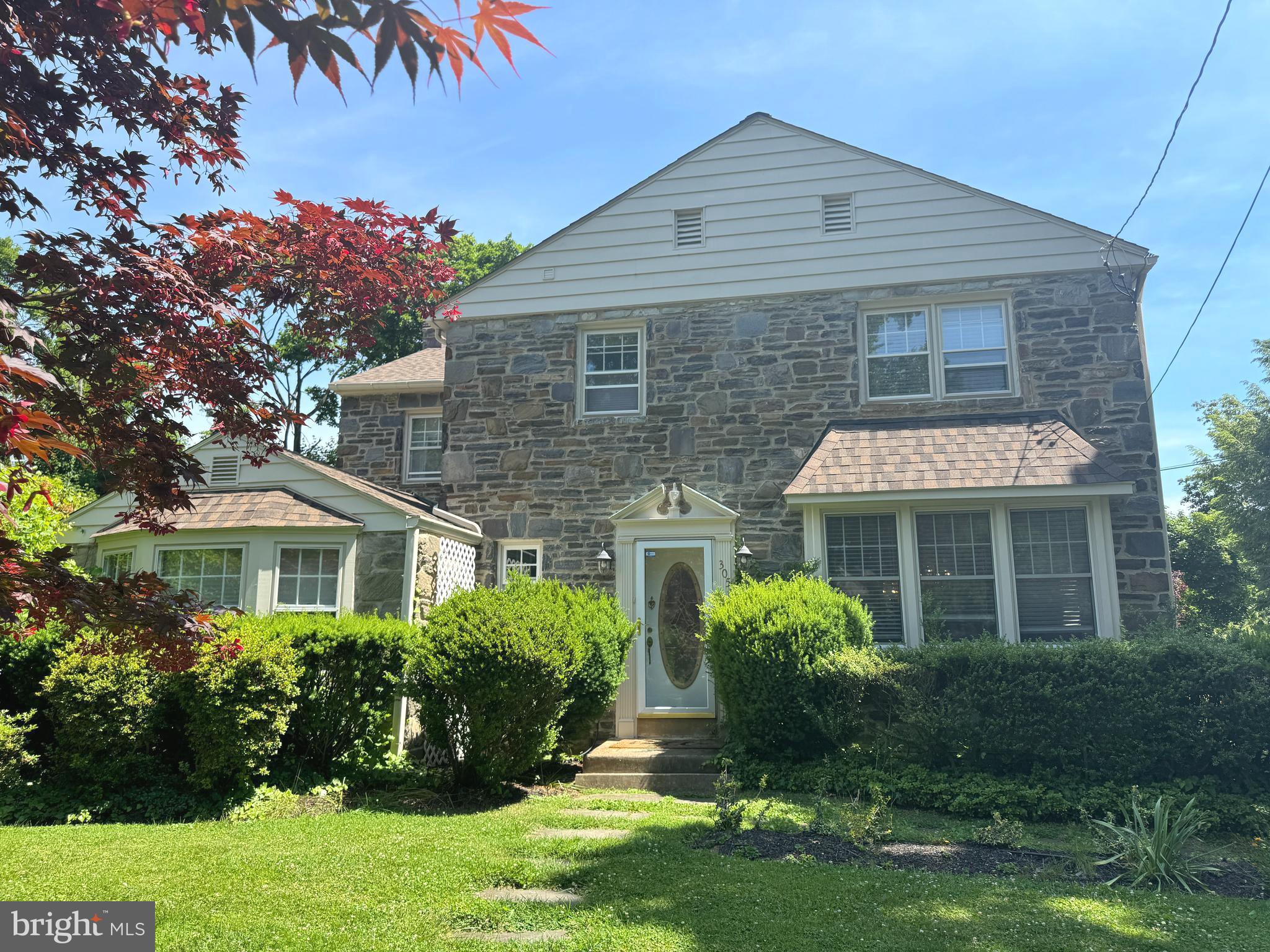 a front view of a house with a yard and potted plants