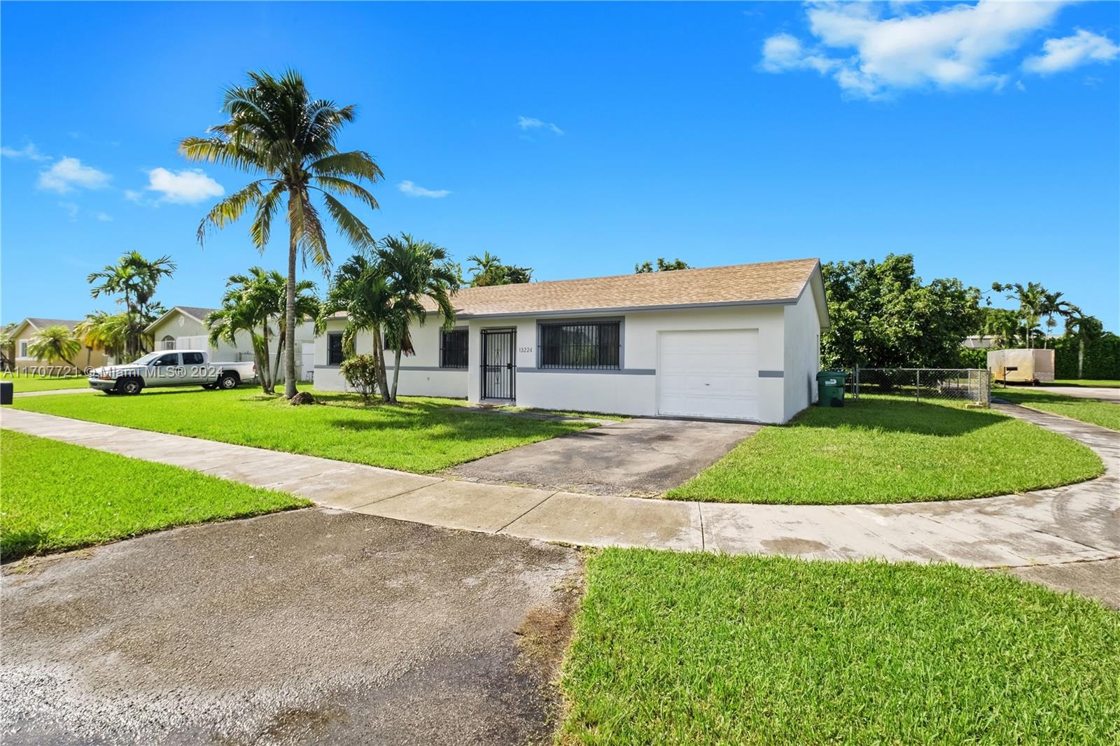 a front view of a house with a yard and potted plants