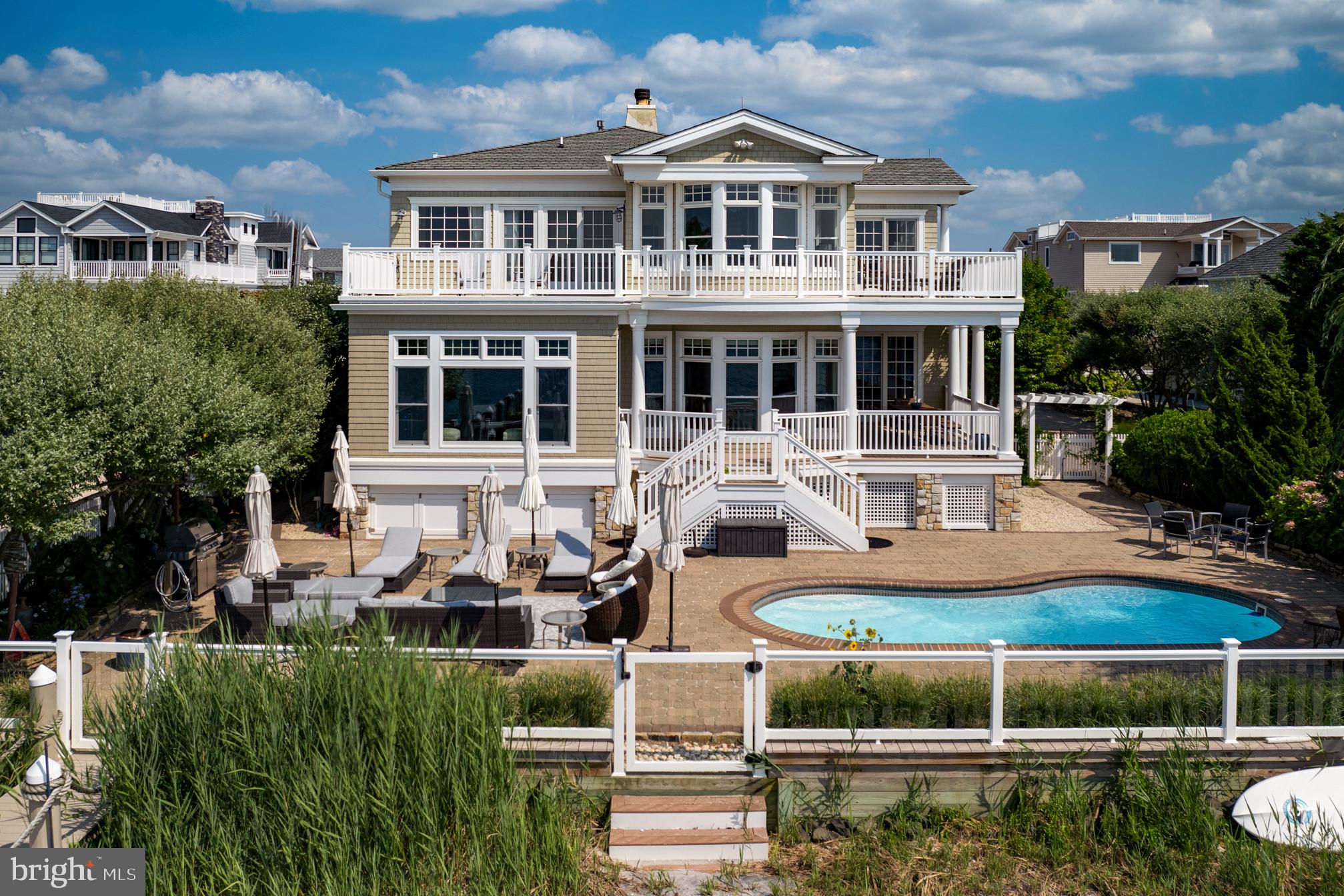 a front view of a house with a garden and swimming pool