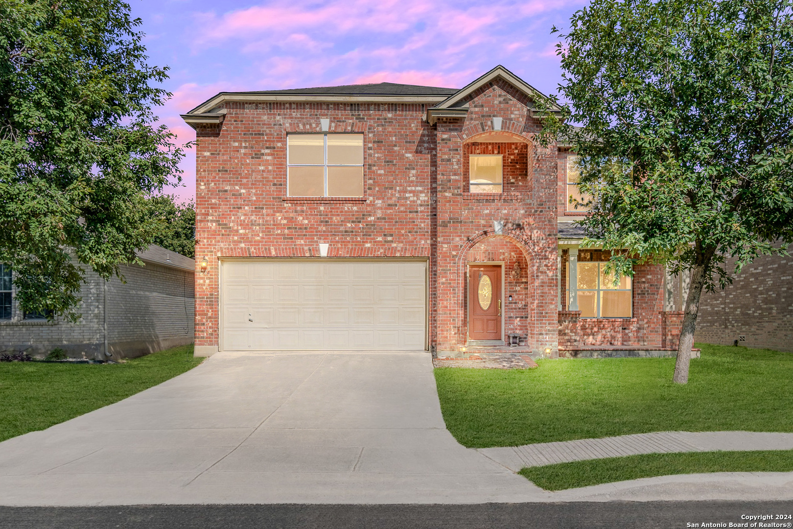 a front view of a house with a yard and garage