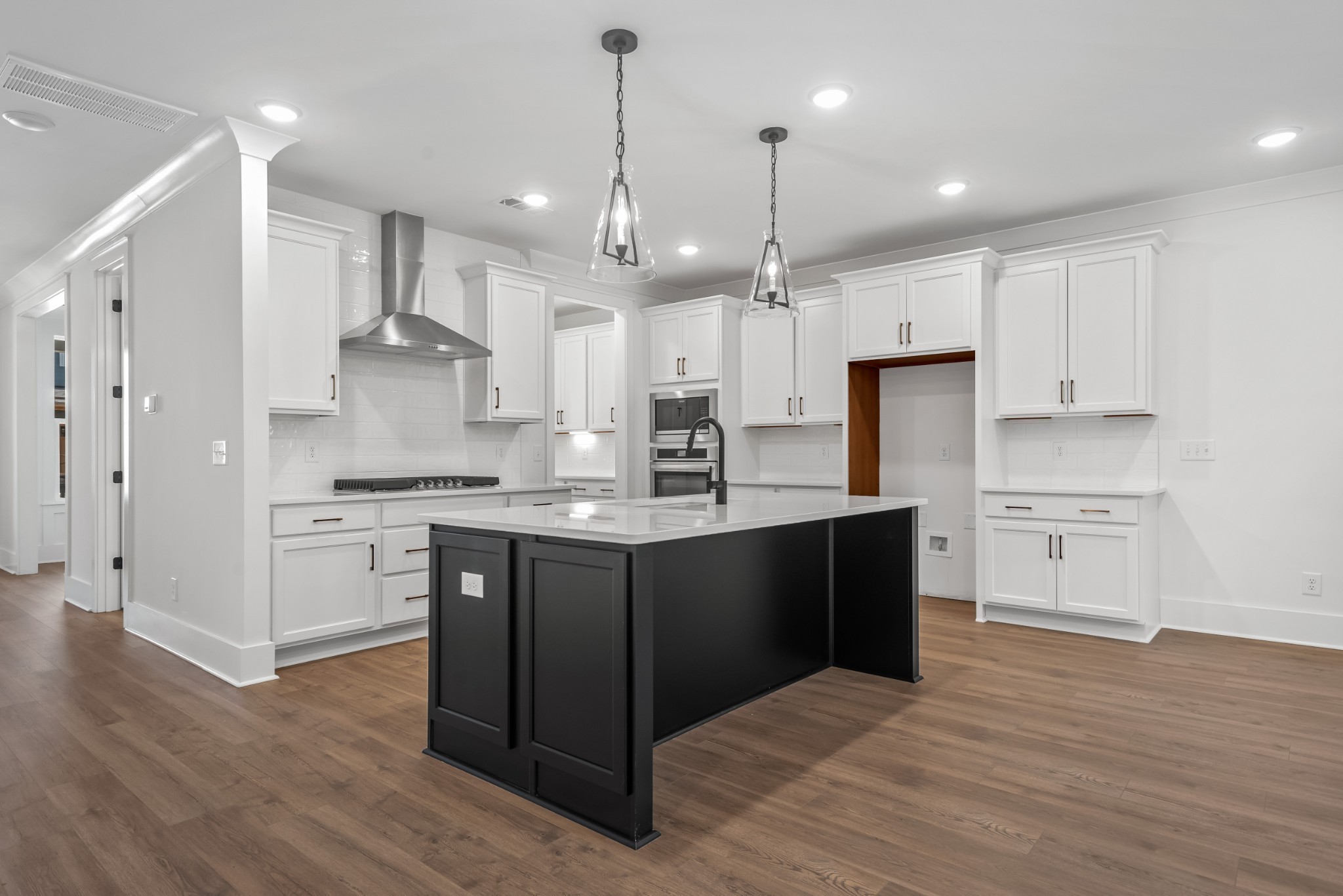 a kitchen with kitchen island granite countertop a sink cabinets and wooden floor