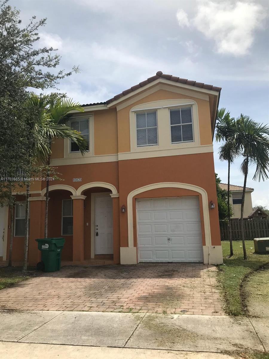 a front view of a house with a yard and garage