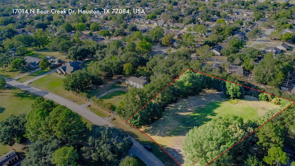 an aerial view of residential house with outdoor space and trees all around