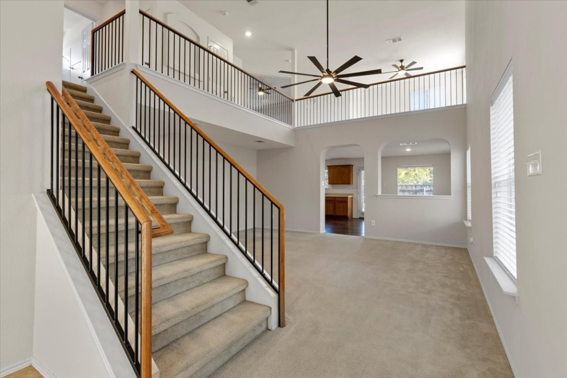 a view of staircase with wooden floor and fan