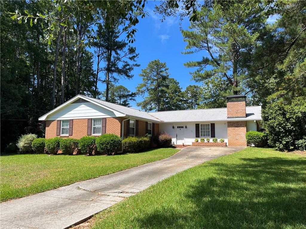 a front view of a house with a yard and trees