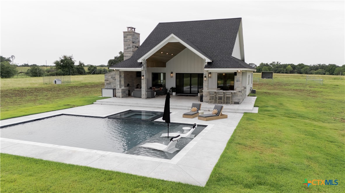 a front view of a house with swimming pool and a yard