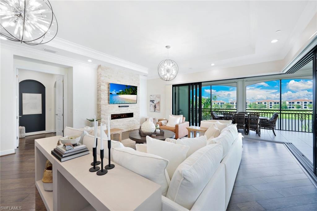 a living room with furniture a fireplace and a floor to ceiling window