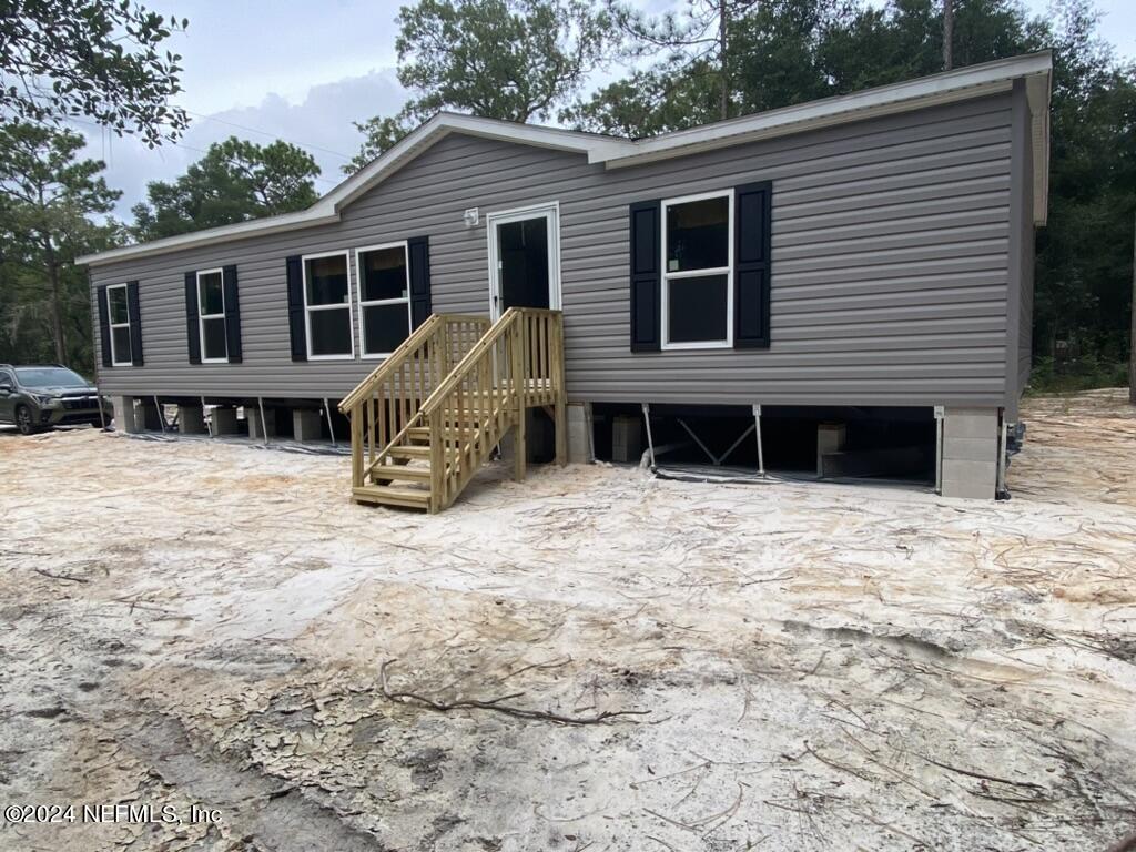 a view of a house with a yard and parking space