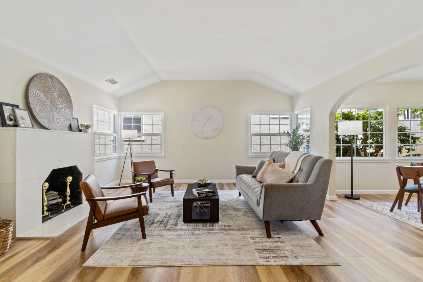 a living room with furniture a rug a fireplace and a large window