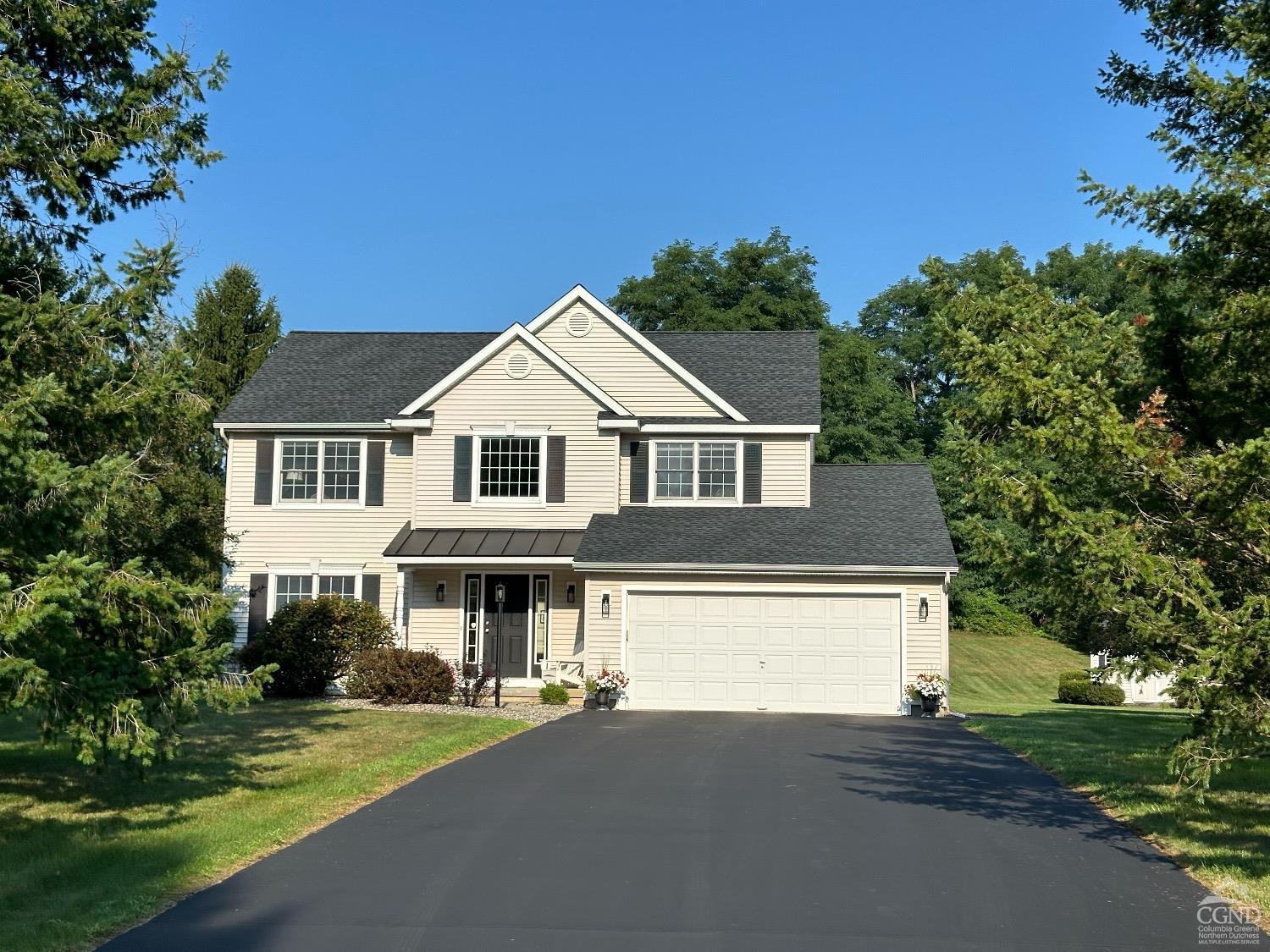 a front view of a house with a garden and yard