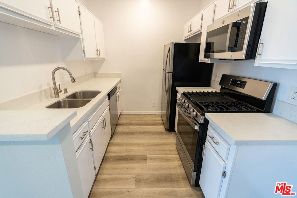 a kitchen with stainless steel appliances granite countertop a sink stove and refrigerator