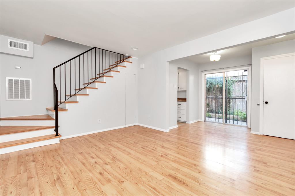 a view of a big room with wooden floor and entryway