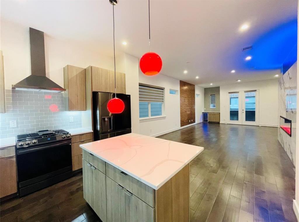 a kitchen with stainless steel appliances granite countertop a stove a sink and a refrigerator