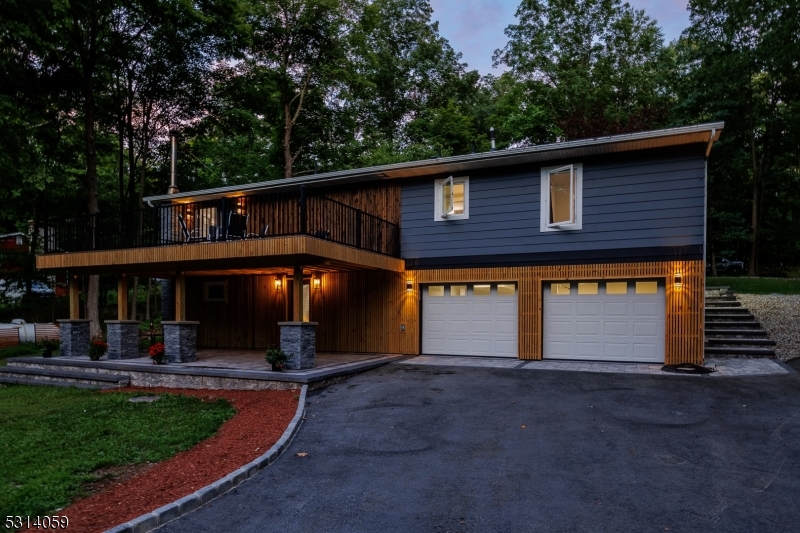 a front view of house with yard and trees in the background