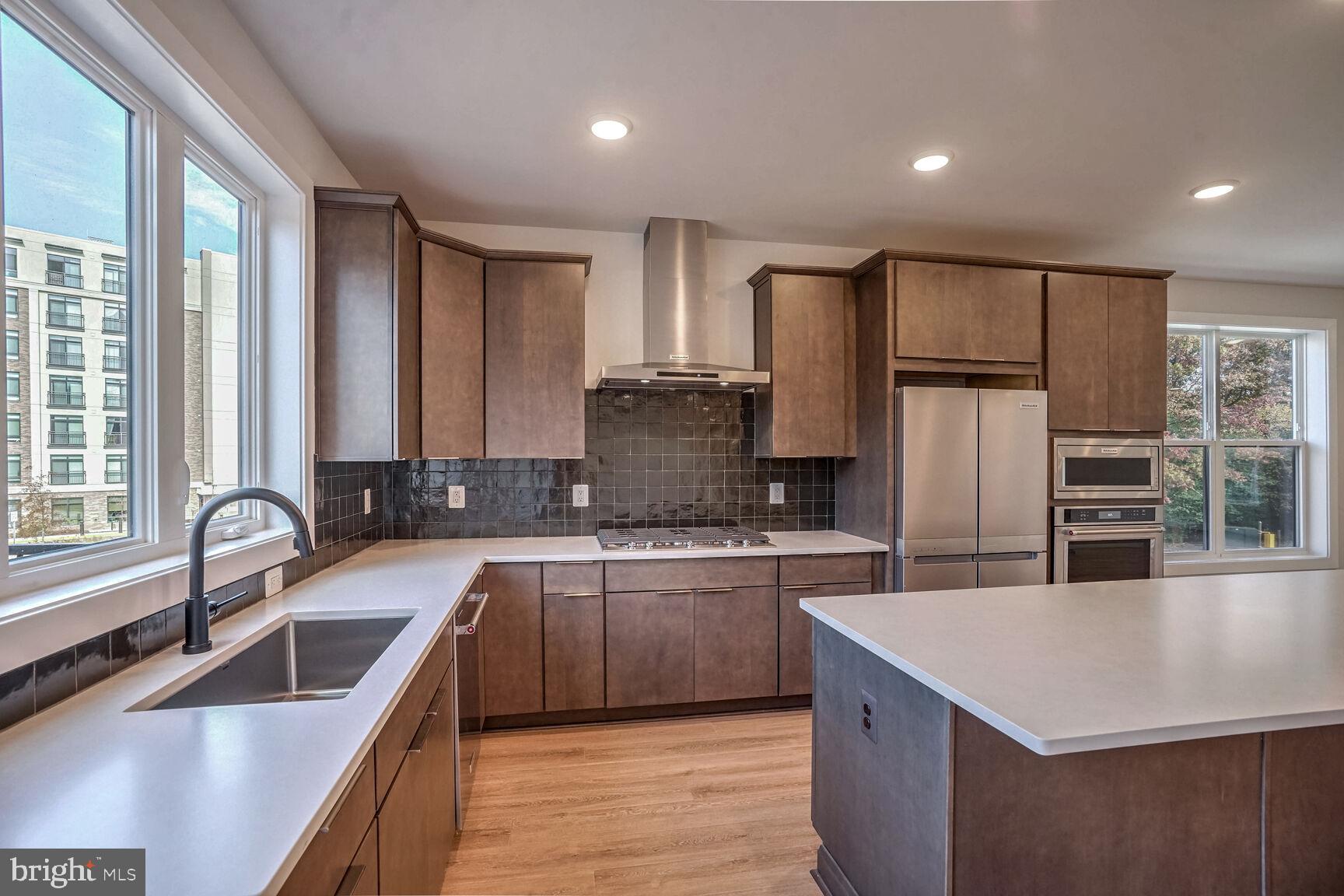 a kitchen with stainless steel appliances granite countertop a sink stove and refrigerator