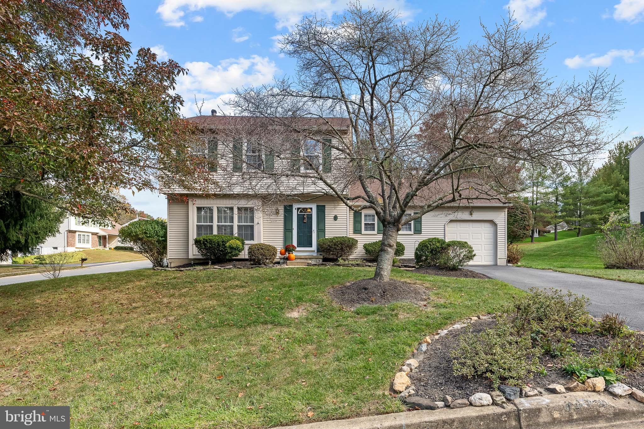 a front view of a house with a yard and trees