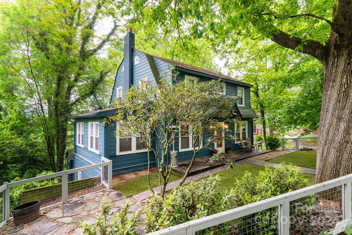 a view of house with a yard and potted plants