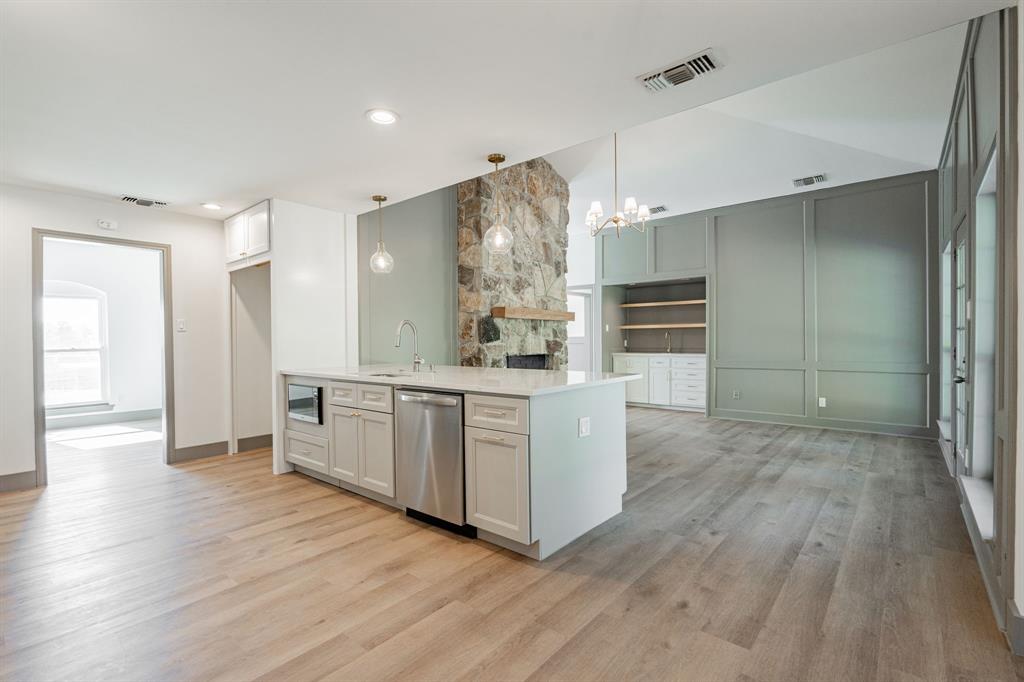 a kitchen with white cabinets and wooden floor