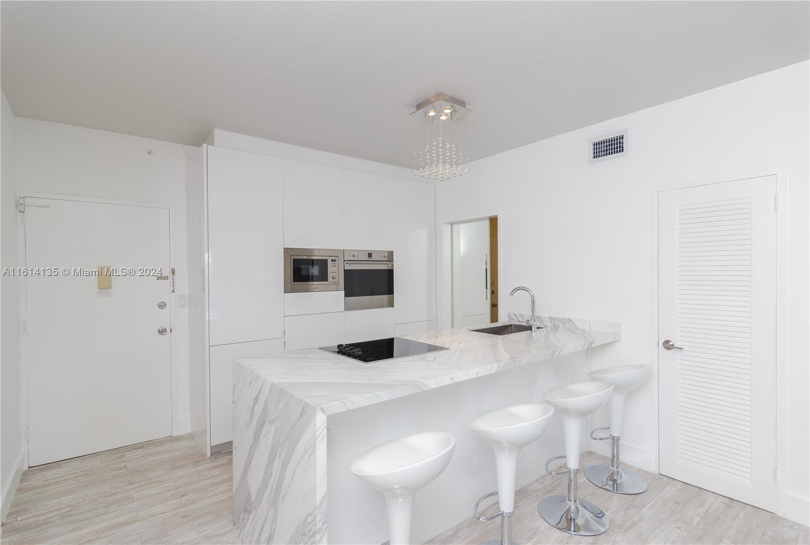 a kitchen with a sink and chairs