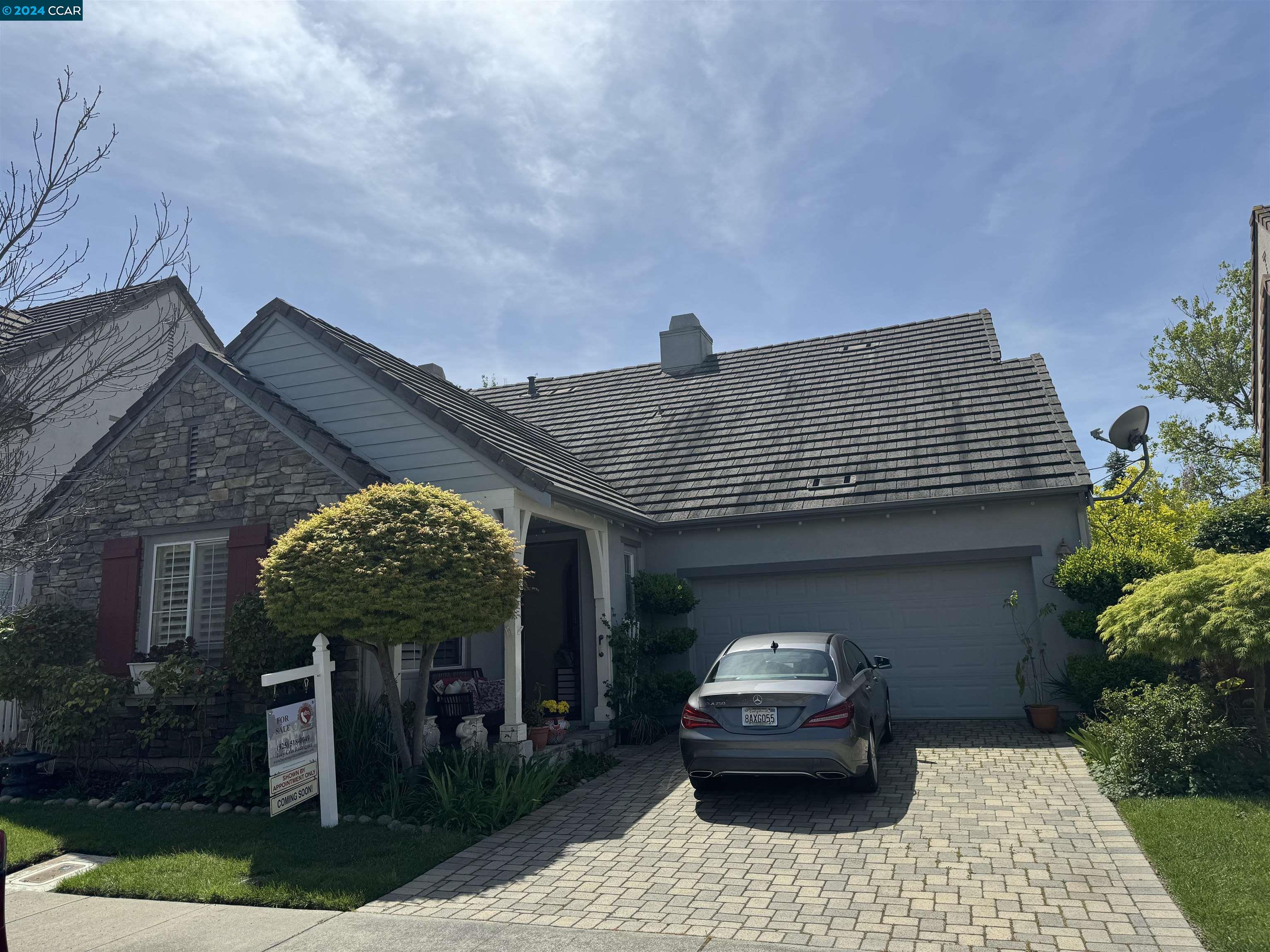 a front view of a house with a garden and plants