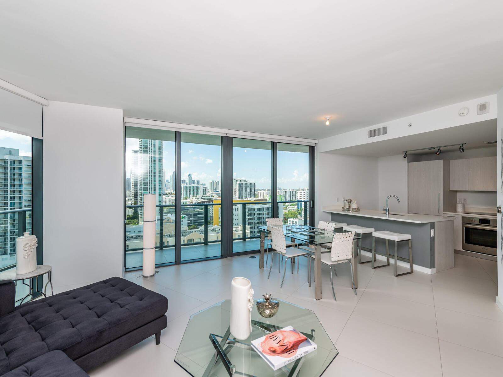 a living room with furniture a rug and a floor to ceiling window