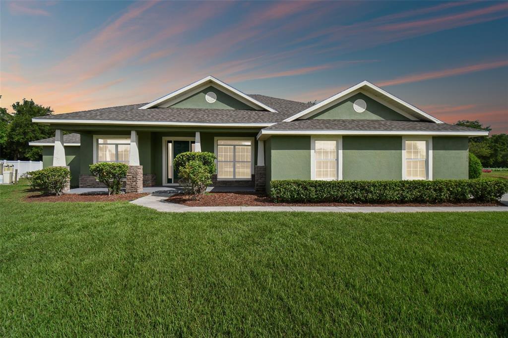 a front view of a house with yard patio and green space