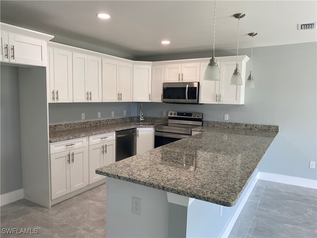 a kitchen with sink a microwave and cabinets