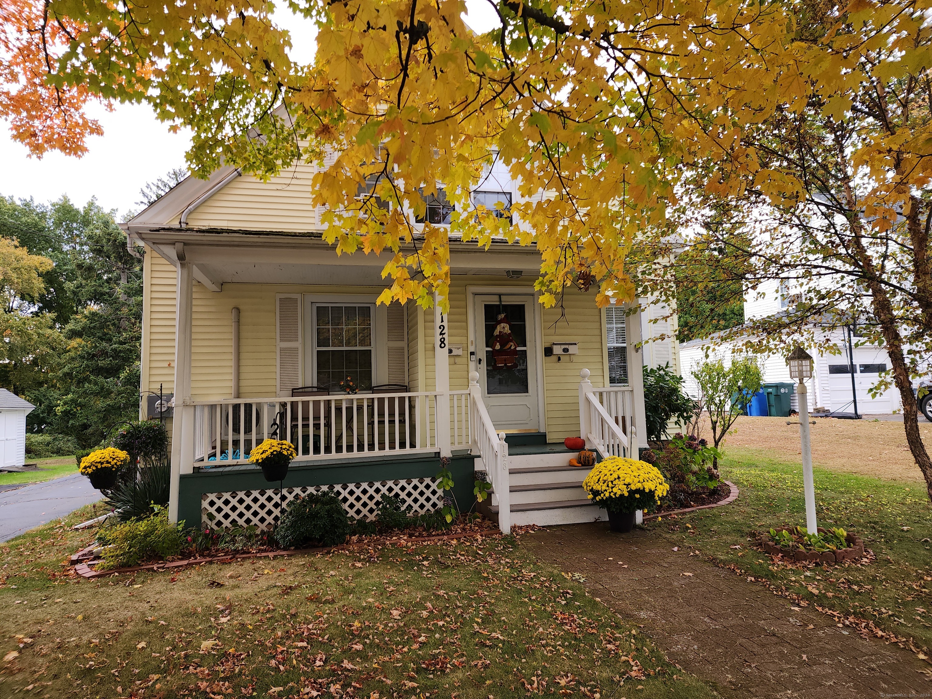 a view of a house with a large tree and a car park in front of house