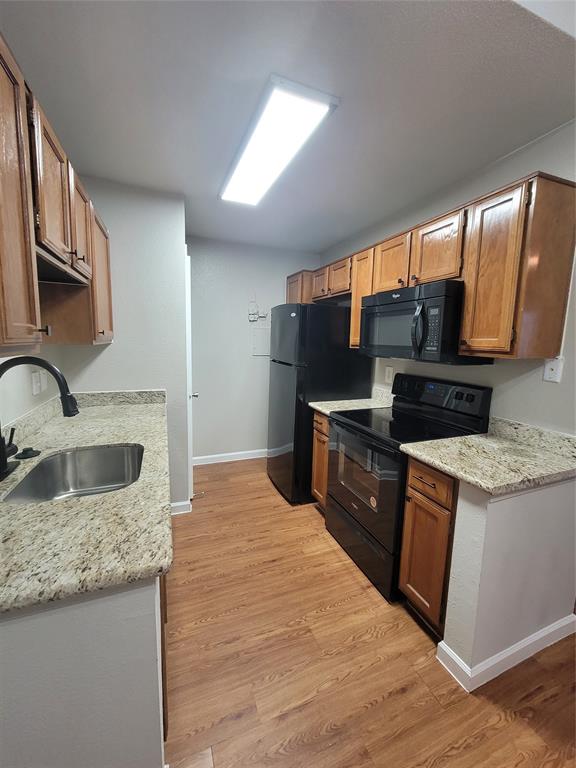 a kitchen with granite countertop a sink stove and refrigerator