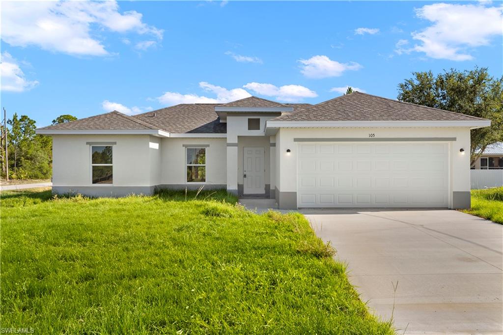 a front view of a house with a yard and garage