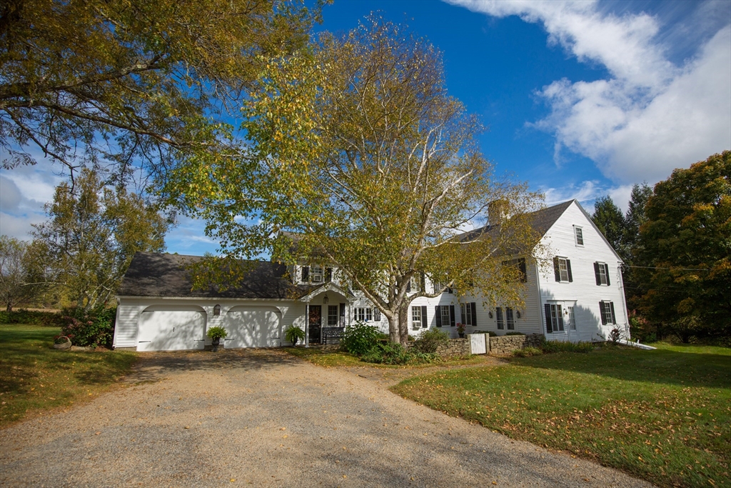 a front view of a house with a yard and trees