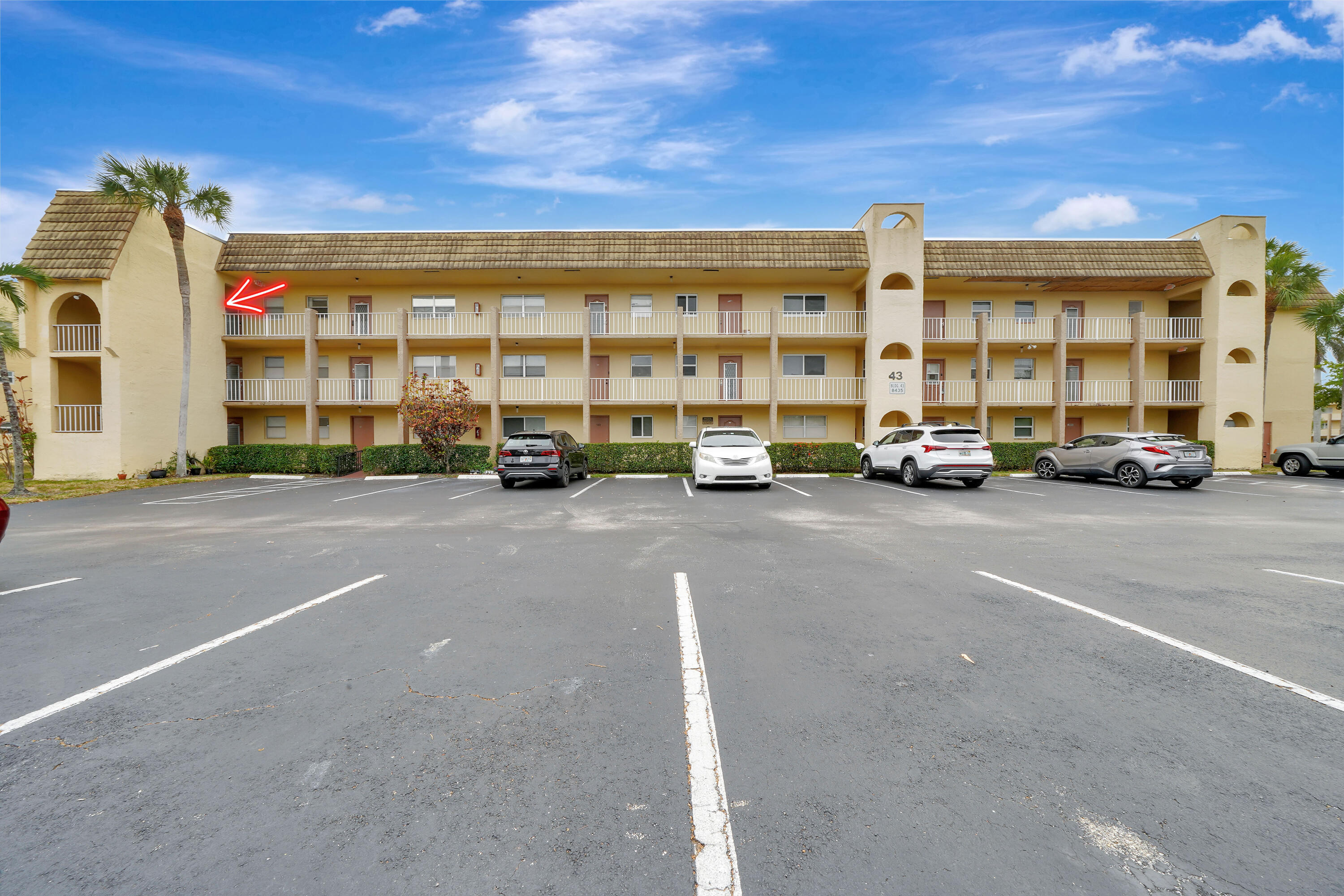 a view of building with cars parked in front of it