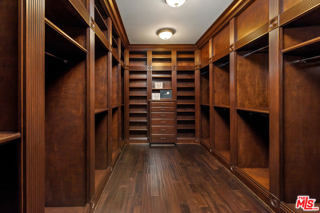 a view of walk in closet with wooden floor