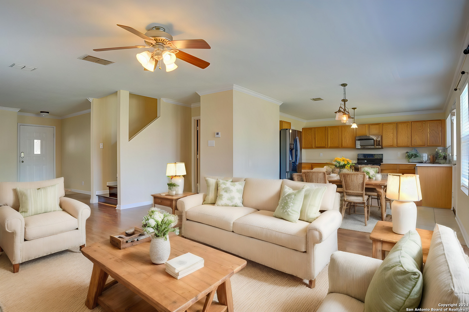 a living room with furniture kitchen view and a chandelier