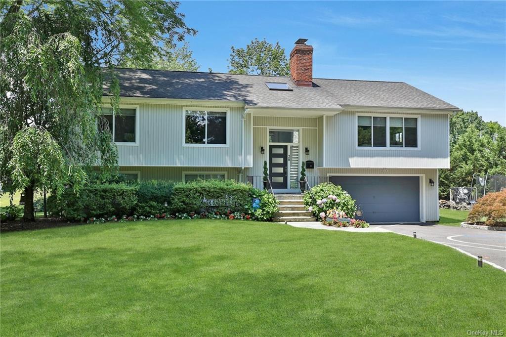 a front view of a house with a garden and plants