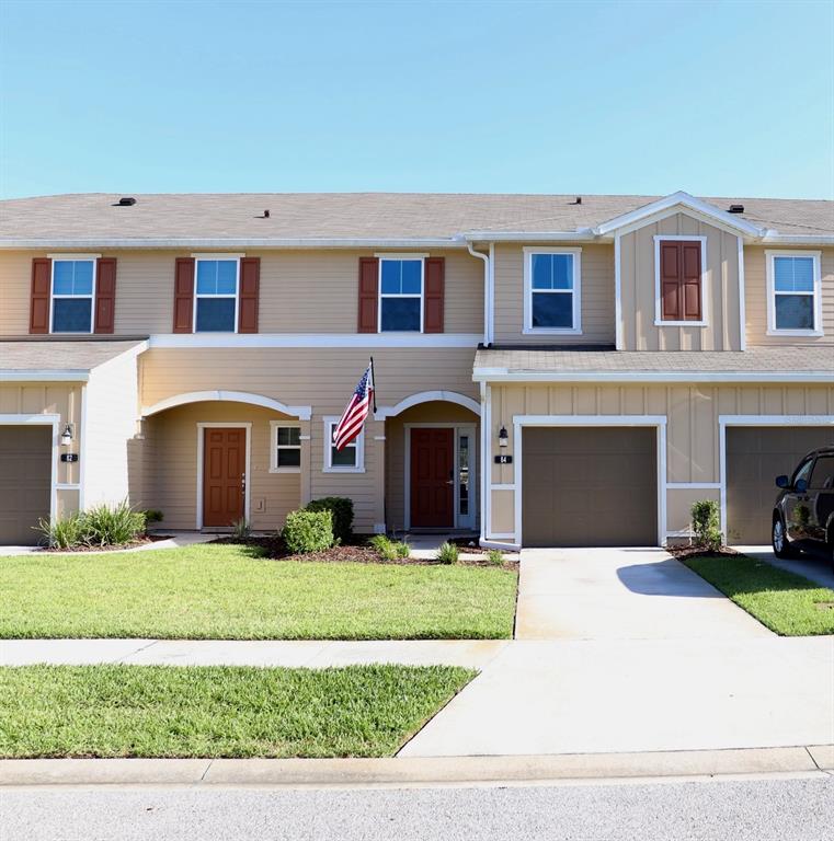 a front view of a house with yard and garage