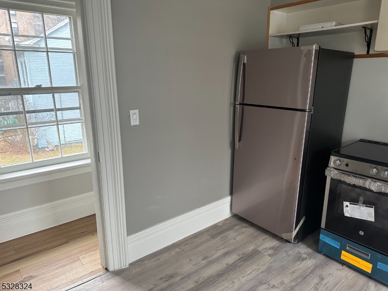 a view of a kitchen with wooden floor and a refrigerator